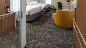 Une chambre d’hôtel avec deux lits, un bureau, une chaise et un canapé.