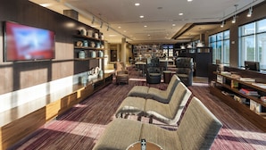 Un espace de détente moderne, doté de sièges confortables, d’un grand téléviseur à écran plat et d’une bibliothèque bien garnie.