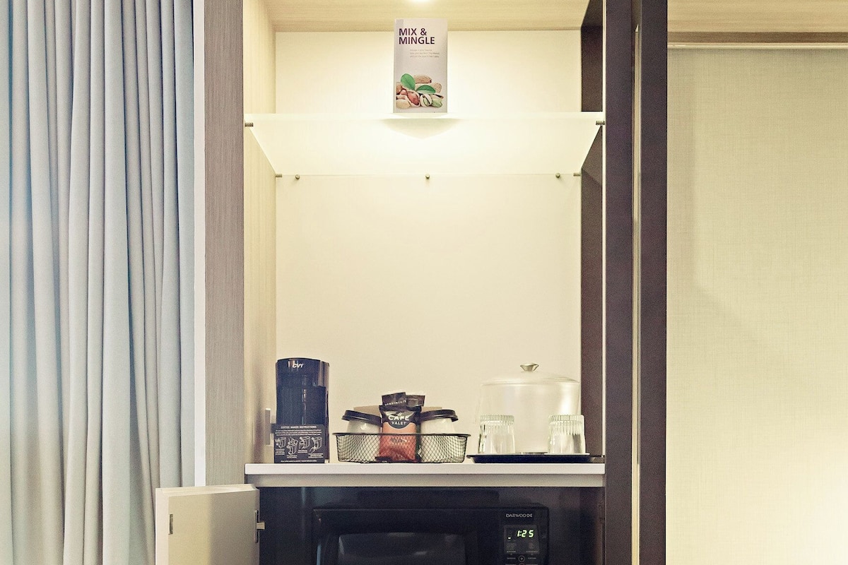 A compact kitchenette with a microwave, coffee maker, and a small refrigerator.