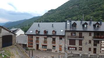 Un edificio de piedra con restaurante y hotel. Tiene techo inclinado y varias ventanas.