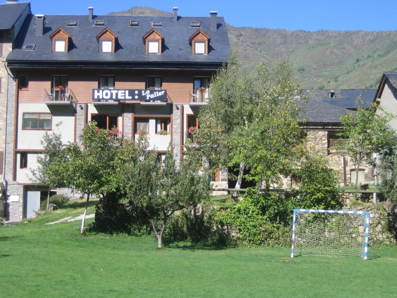 Un hotel con un cartel que dice "HOTEL Lo Paller" y una portería de fútbol visible en el exterior.