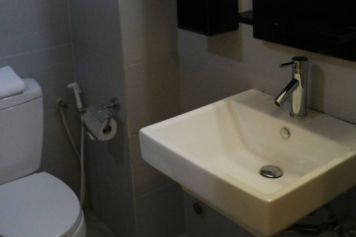 A bathroom with a toilet, a sink, and a mirror.