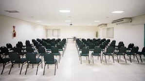 A conference room with rows of chairs, a table, and a projector screen. - Francisco Beltrao Palace (Francisco Beltrao)