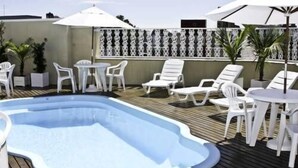 A swimming pool with lounge chairs and umbrellas. - Francisco Beltrao Palace (Francisco Beltrao)