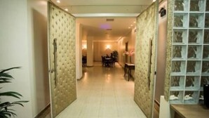 A hotel corridor with a dining area in the distance, a large window with a view, and a reception desk. - Francisco Beltrao Palace (Francisco Beltrao)