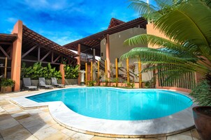 Una piscina al aire libre, sillones reclinables de piscina