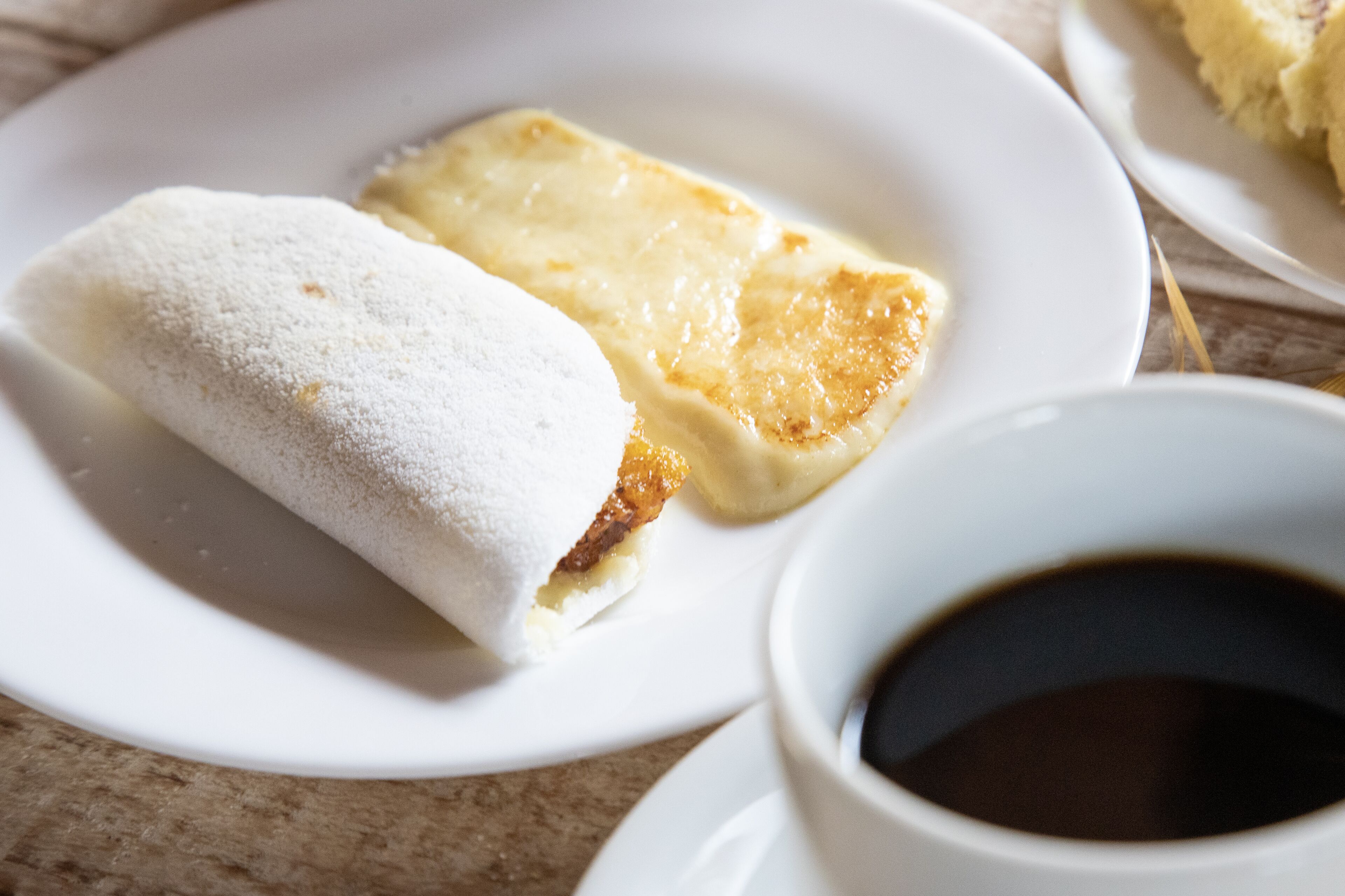 Un plato con un pastel y una taza de café.