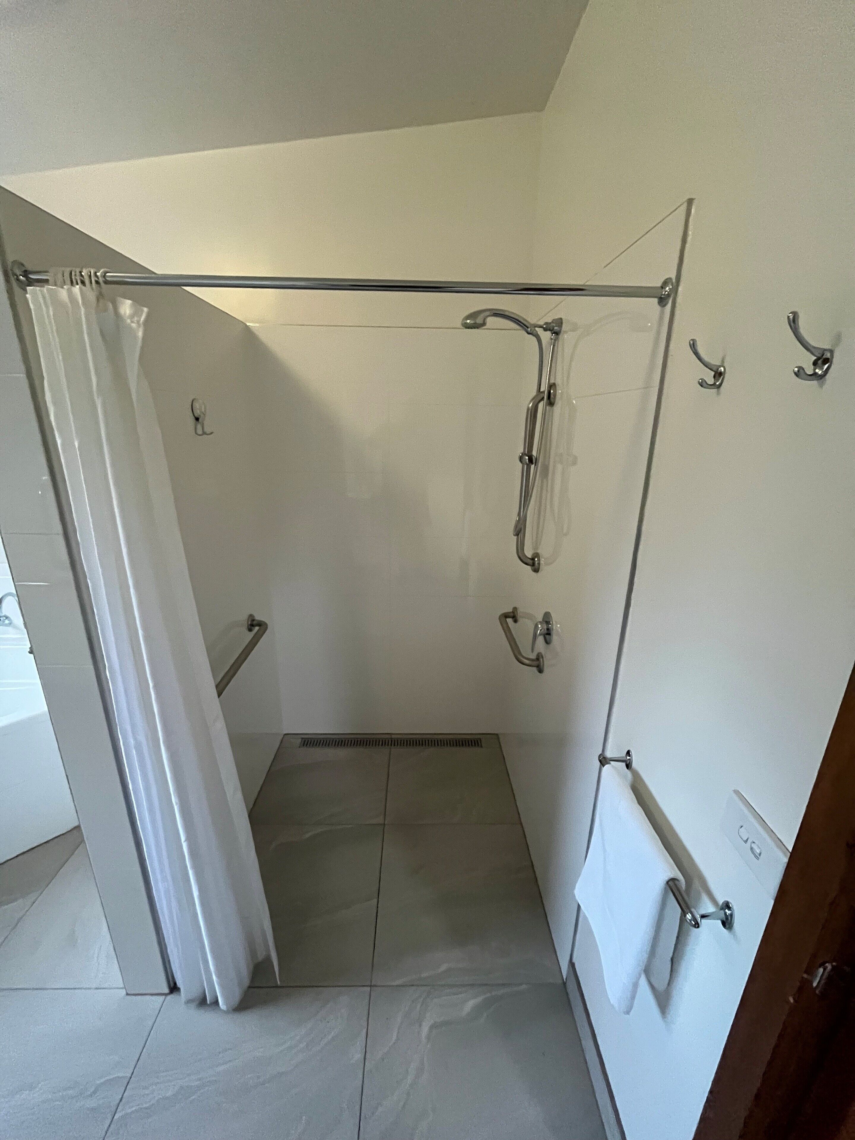 A bathroom with a shower, a toilet, and a sink.