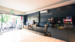 A modern cafe interior with a seating area, a counter with beverages, and an air conditioning unit on the wall. - Kenting Starry Sky - Space Capsule (Hengchun)