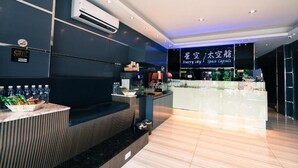 A modern hotel lobby with a reception desk, air conditioning units, and a digital sign displaying "Starry sky / Space Capsule". - Kenting Starry Sky - Space Capsule (Hengchun)