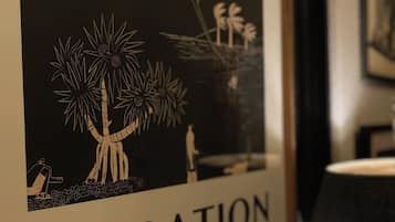 A framed artwork with a tropical theme, including palm trees and a person in a hammock, labeled "VACATION".