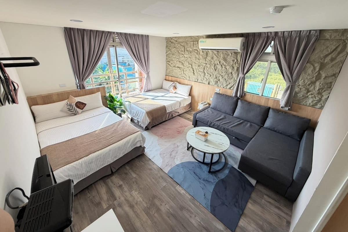 Una habitación de hotel moderna con cama, sofá y una mesita.