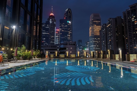 Una piscina al aire libre, sillones reclinables de piscina
