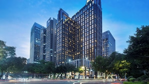 A modern high-rise building with multiple floors, large windows, and a prominent entrance.