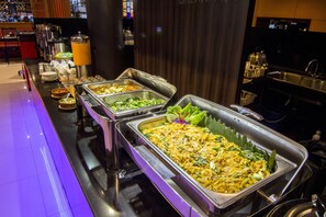A buffet with various food options, including noodles and salads, in a well-lit indoor setting. - Citi M Hotel (Jakarta)