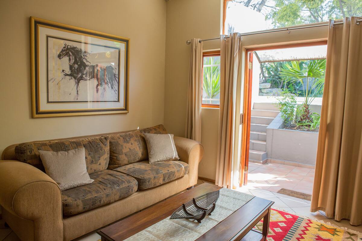 Ein Wohnzimmer mit einer Couch, einem Couchtisch und einem gerahmten Bild an der Wand.