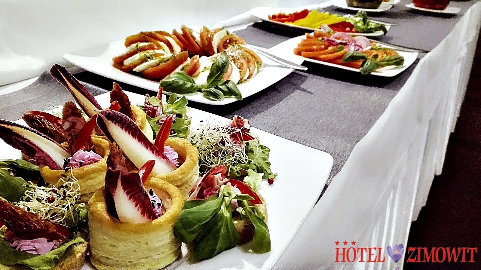 A buffet table with various plated dishes, including salads and appetizers.