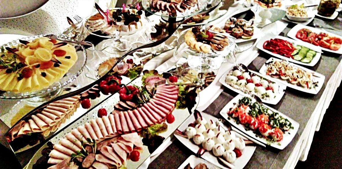 A buffet table with various food items and utensils.