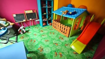 Children can play and explore in this lively room with a playhouse, bookshelf, and table.