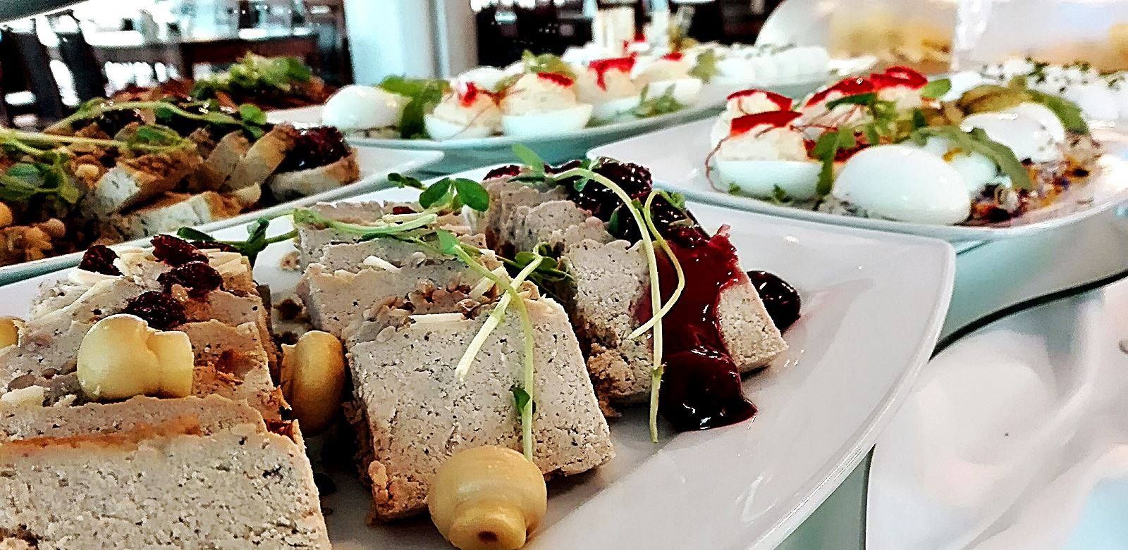 Un assortiment de petites bouchées présentées sur des assiettes, accompagnées de garnitures et de sauces.