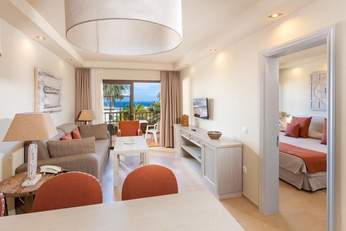 Une chambre d’hôtel moderne comprenant un espace de vie, un coin repas et une chambre à coucher.