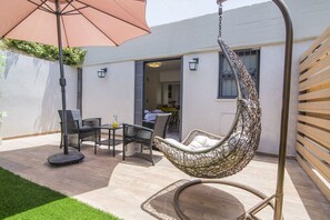 Suite estudio Deluxe, 1 cama Queen size, patio | 1 habitación, caja de seguridad en la habitación y escritorio 