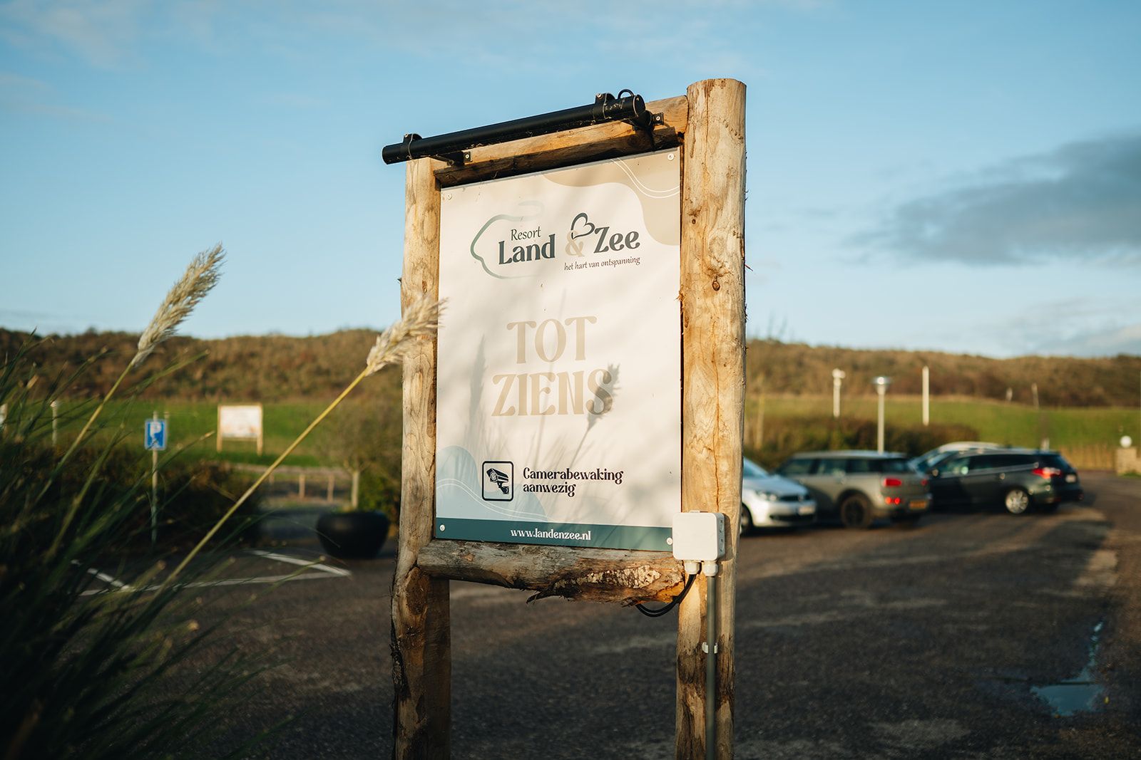 Un panneau indicateur pour le complexe hôtelier Resort Land Lee, avec le message « À ZIENS » et un lien vers le site web.