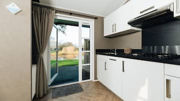 Een moderne keuken met witte kasten, een zwart aanrecht en een ingebouwde kookplaat.
