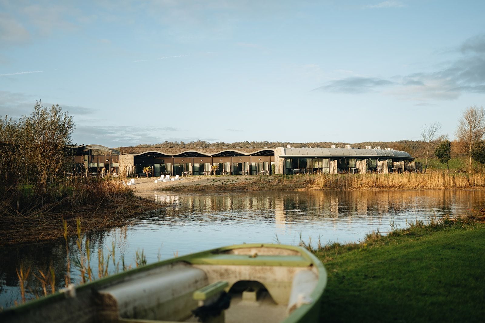 Un hotel junto al río con varias habitaciones y un comedor, rodeado de paisaje natural.