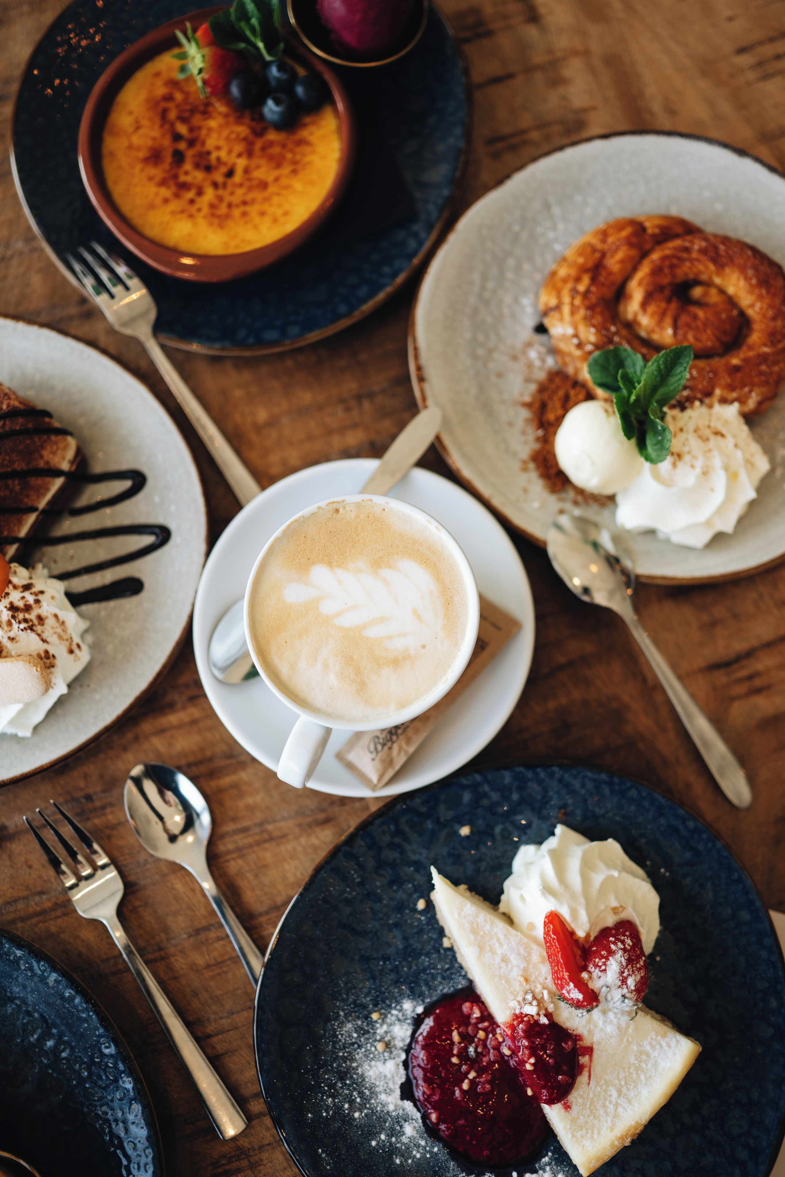 A variety of breakfast dishes including pancakes, a bowl of soup, and a cup of coffee.