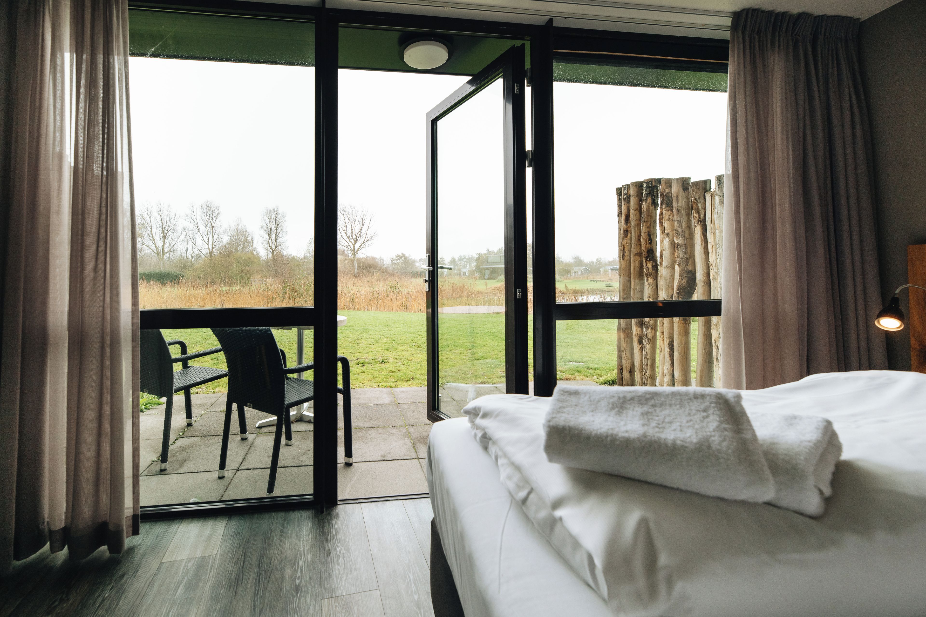 A bedroom with a large sliding glass door leading to a patio area.