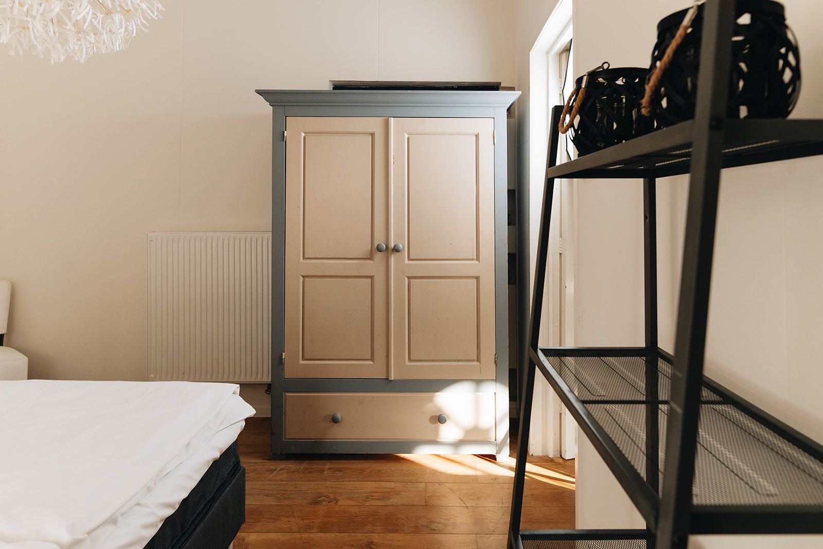 Een slaapkamer met een bed, een kledingkast en een plankunit.
