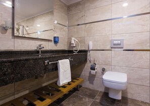 A modern bathroom with a marble vanity, a towel rack, a hairdryer, a toilet, and a mirror. - Lonicera City Hote (Alanya)
