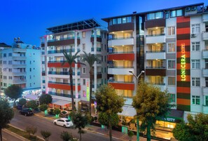 A multi-story hotel with balconies, a parking area, and a street view. - Lonicera City Hote (Alanya)