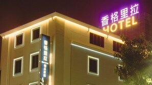 A hotel with multiple floors, illuminated windows, and a neon sign. - Hsiangkelira Hotel (Kaohsiung)