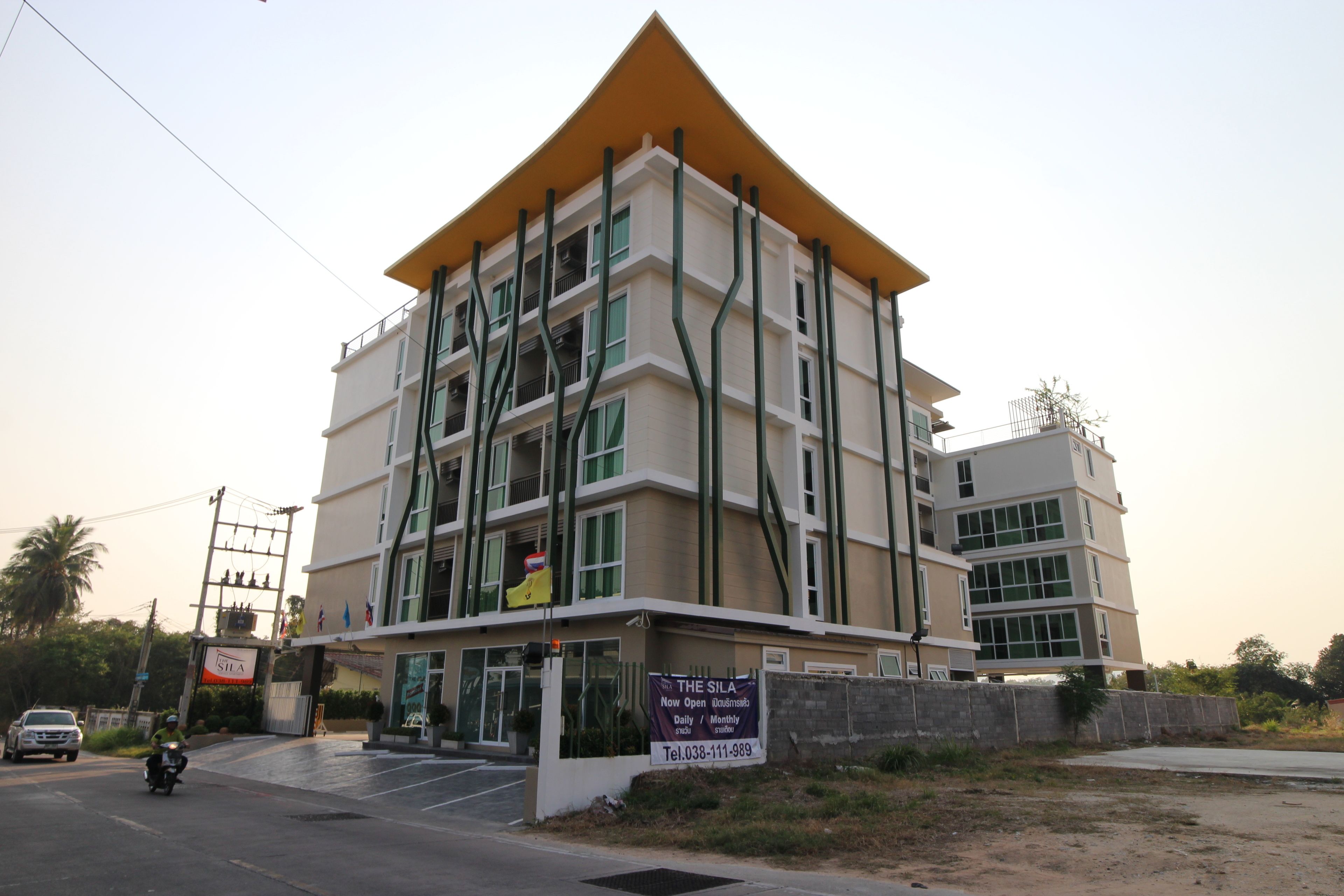 A multi-story building with a distinctive yellow roof and a sign indicating it is a business center.