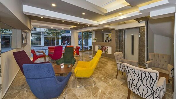 A modern lobby with a mix of seating options, including a bar area with a counter and chairs. - Metrolux Hotel (Istanbul)