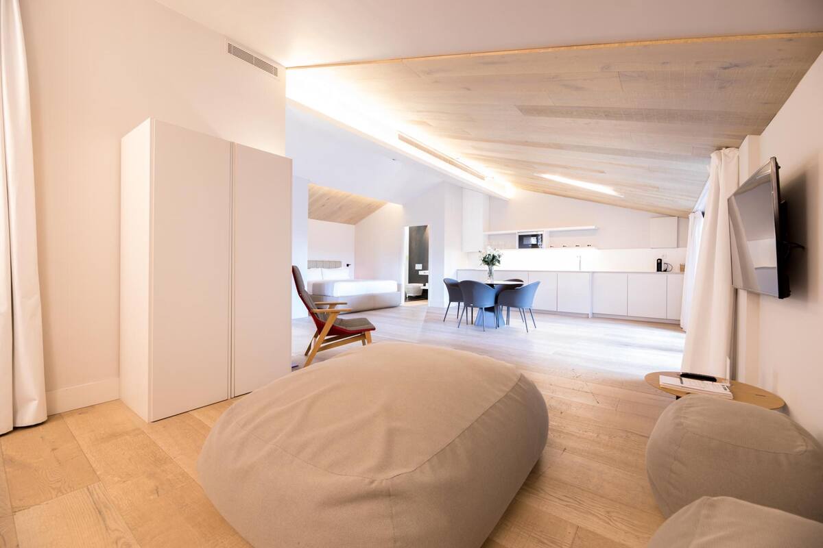A modern, open-plan living space with a kitchen, dining area, and seating area.