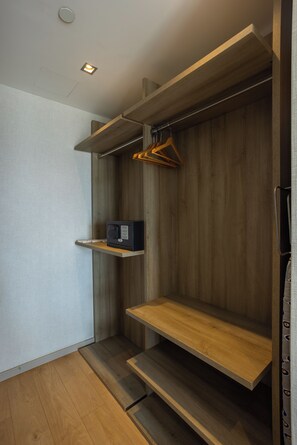 A modern bathroom with wooden shelves, a towel rack, and a small electronic device on a shelf. - Antasya Suites (Istanbul)