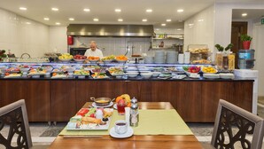 A buffet setup with various food items and a chef in the background. - Darkmen 2 Hotel  (Istanbul)