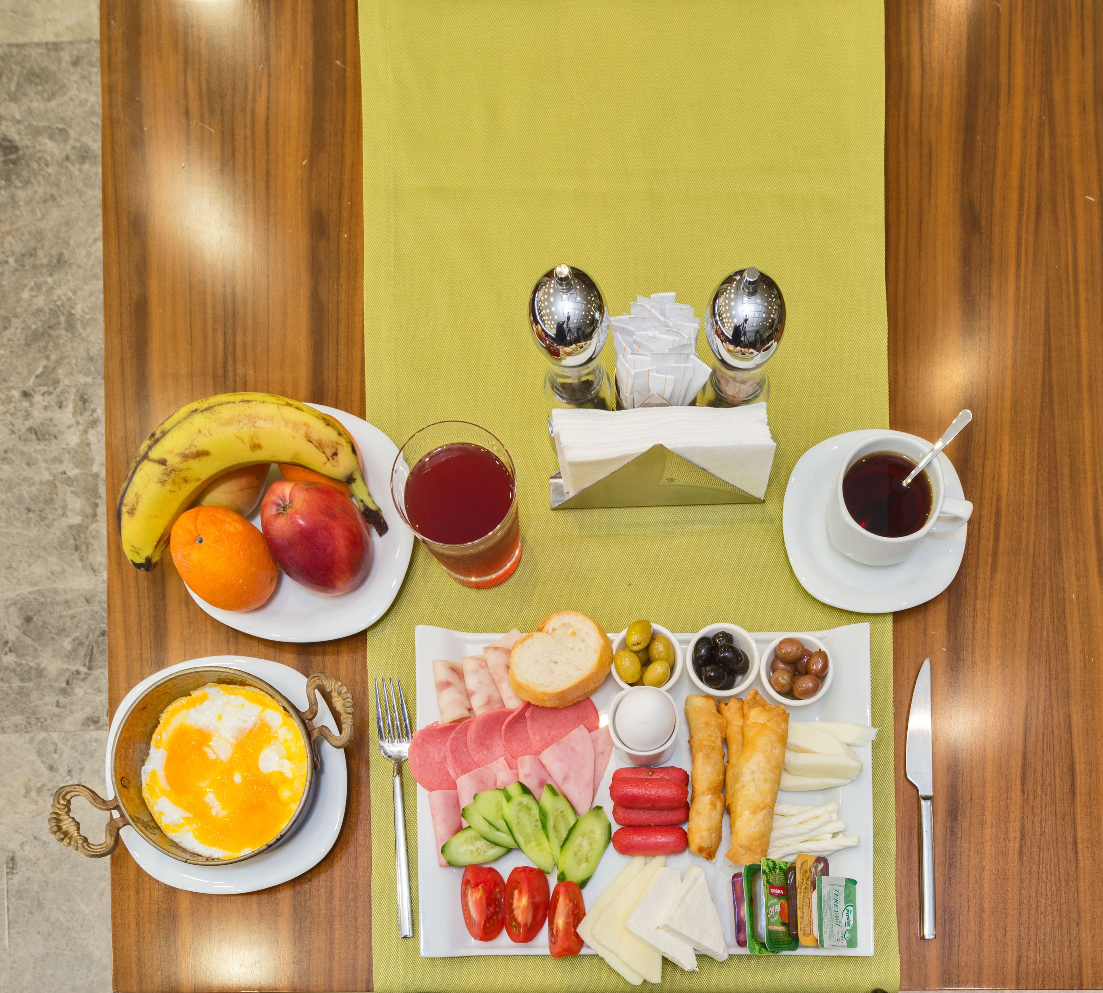 Una mesa de madera con una variedad de alimentos y bebidas para el desayuno.