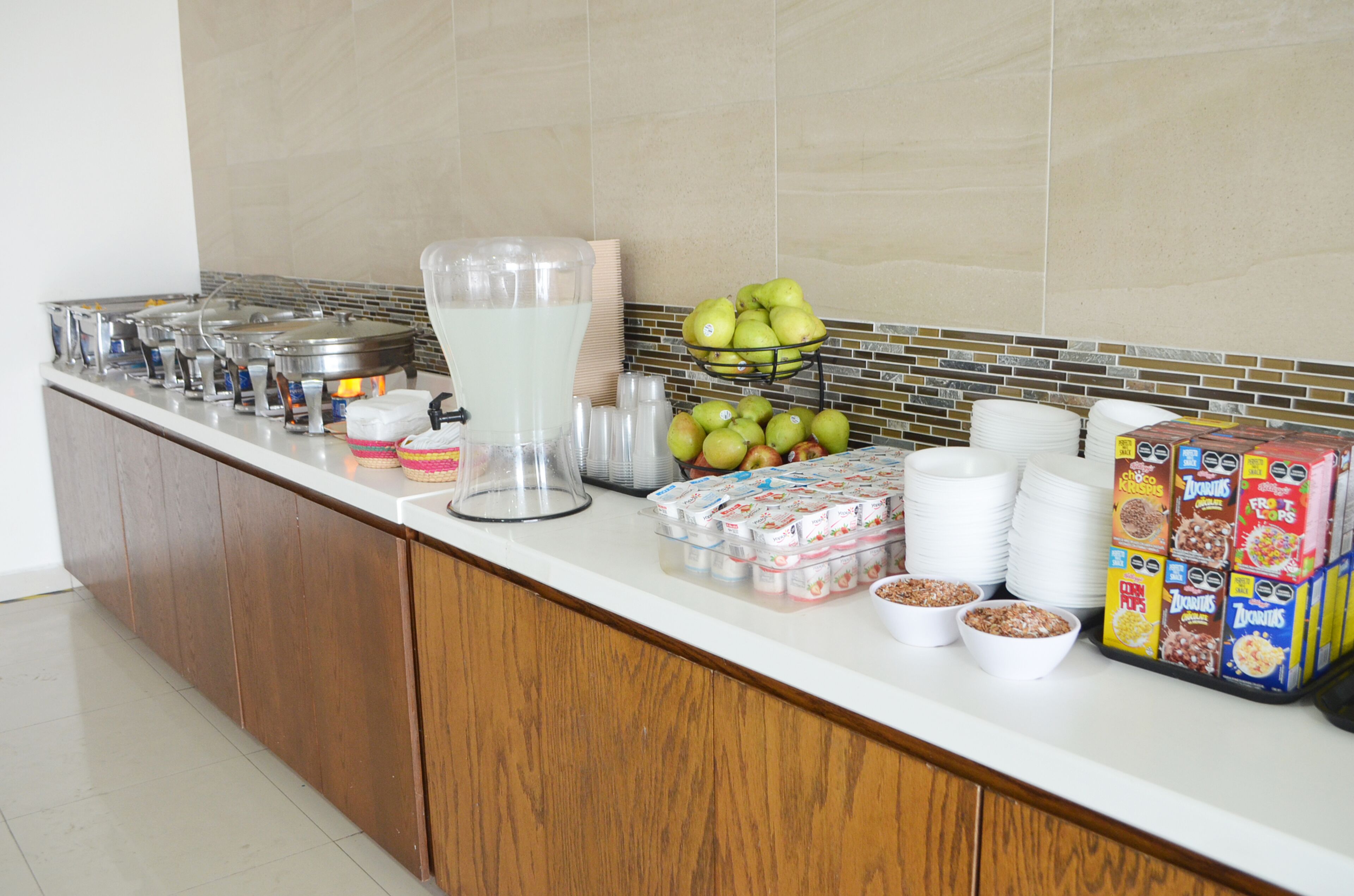 Disposição de buffet com diversos alimentos e bebidas.