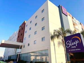 A multi-story building with a Sleep Inn sign, indicating it's part of the Choice Hotels chain.