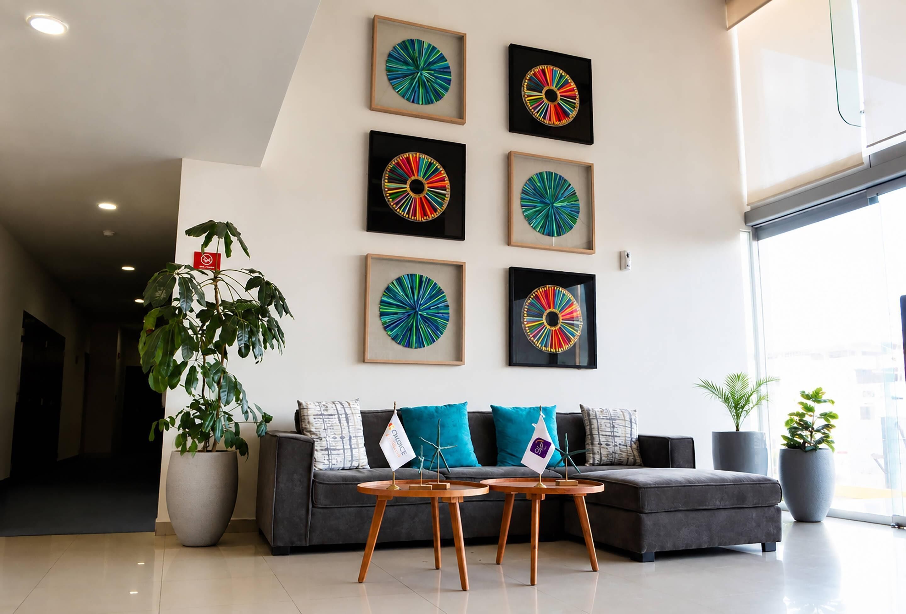 Una sala de estar moderna con un sofá gris, cojines color turquesa y una mesa de centro de madera.