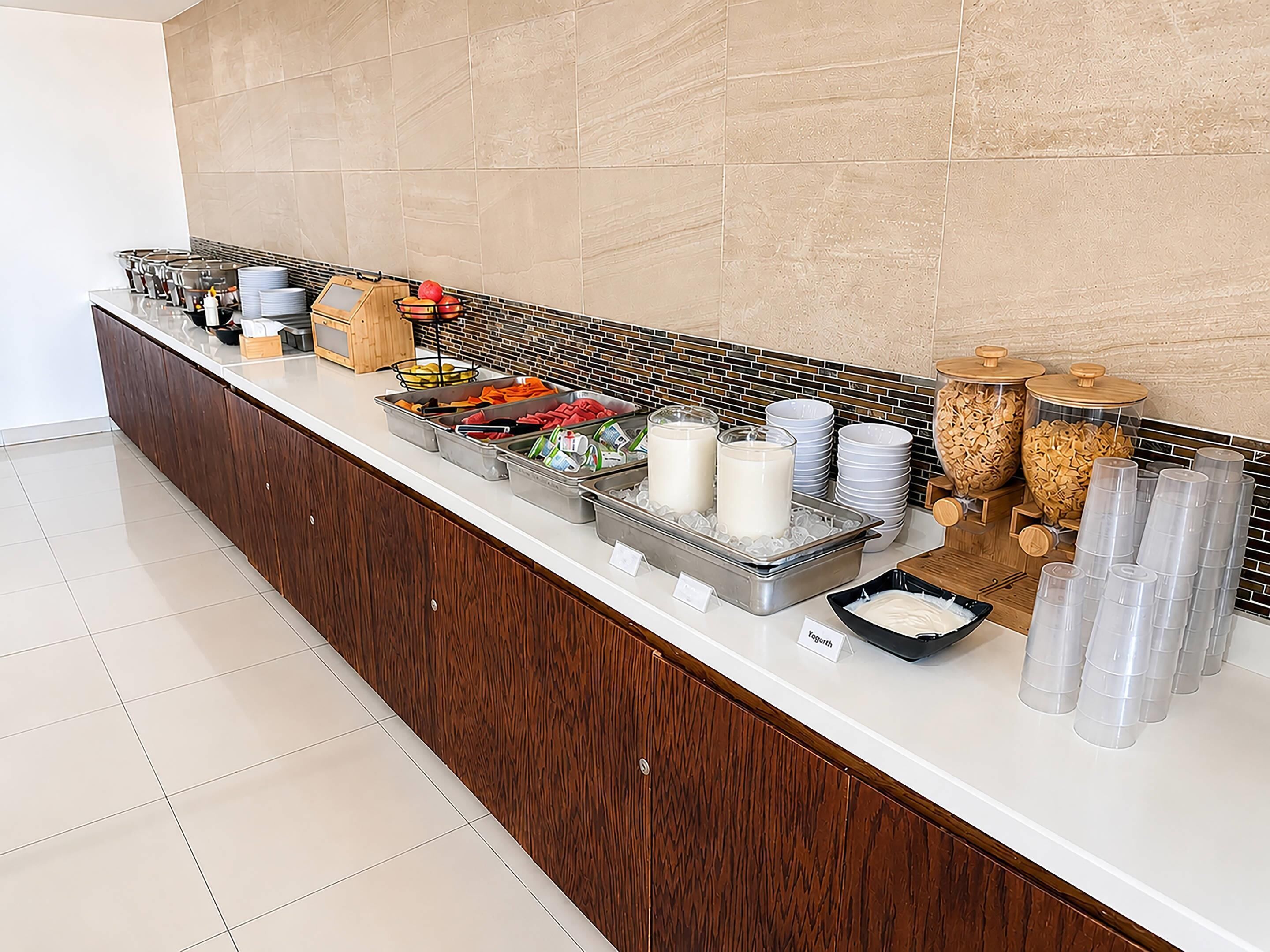 Montaje de bufé con diferentes alimentos y recipientes.