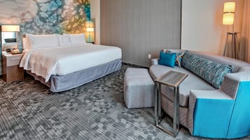 Ein Hotelzimmer mit einem großen Bett, einem Schlafsofa, einem kleinen Tisch und einer Lampe.