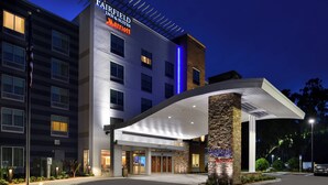 Un hôtel Fairfield Inn & Suites Marriott au design moderne, doté d’une entrée couverte et d’un pilier en pierre portant le nom de l’hôtel.