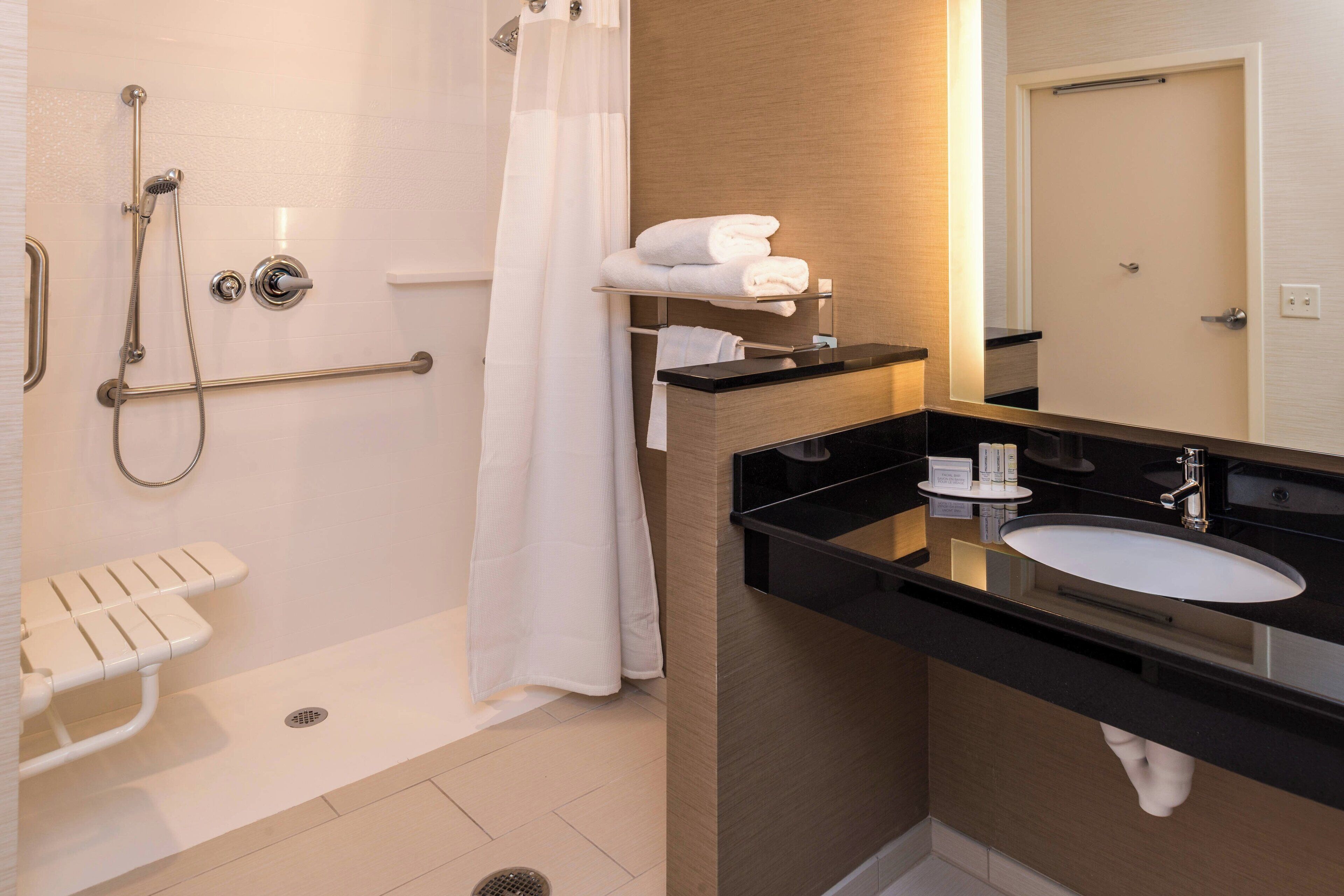 Un baño moderno con bañera, ducha y tocador con lavabo.