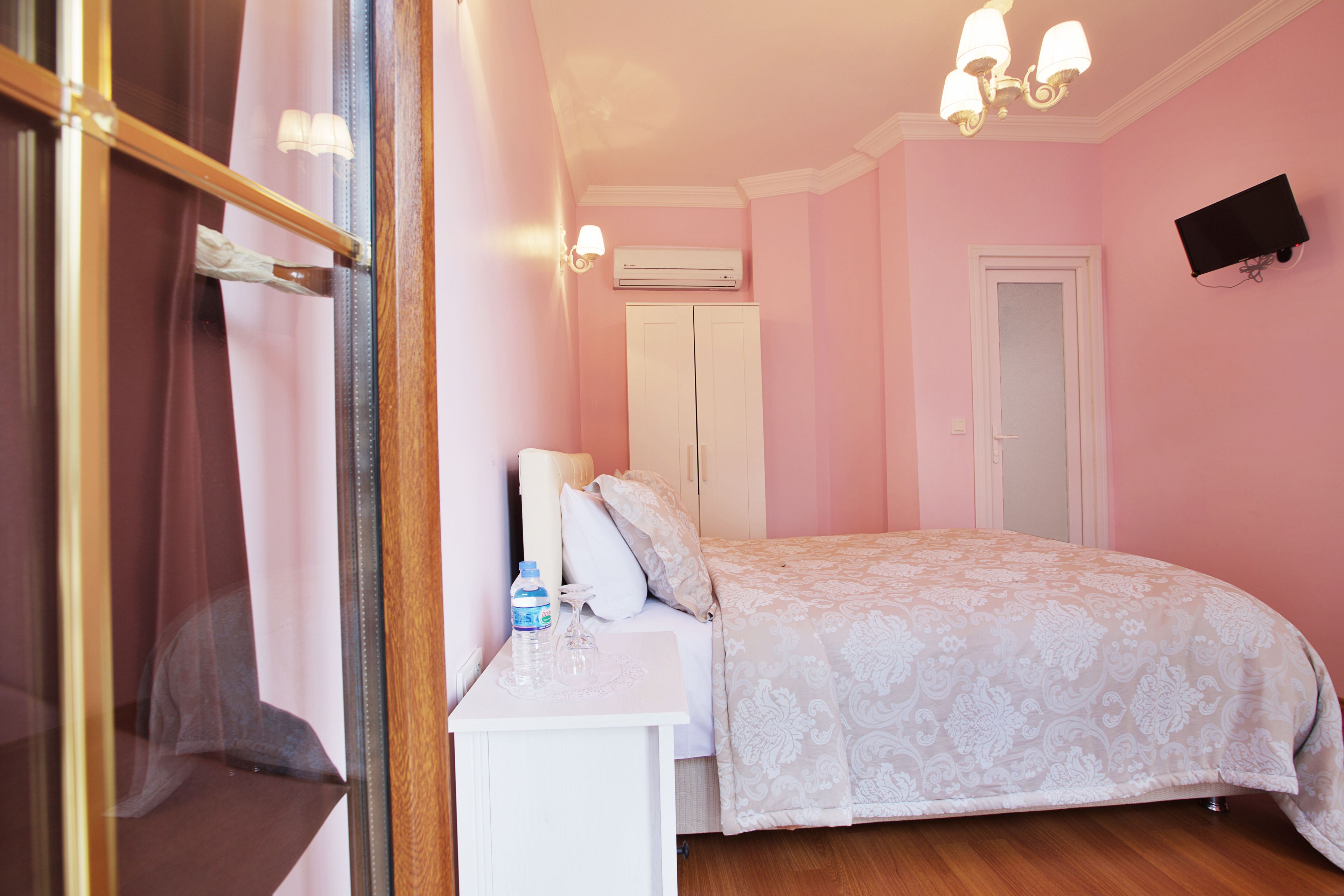 Un dormitorio con cama, mesita de noche y unidad de aire acondicionado.