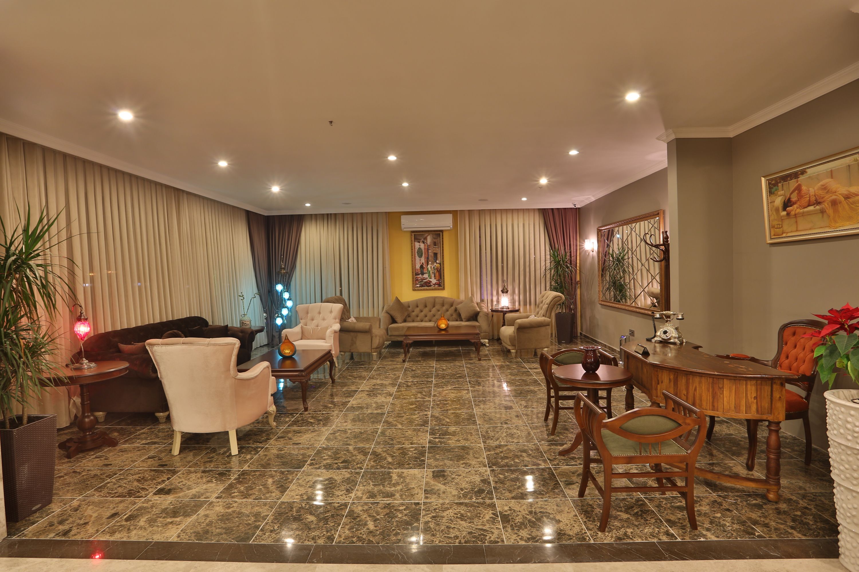 A spacious living room with a large sofa, armchairs, a coffee table, and a dining area with a wooden table and chairs.